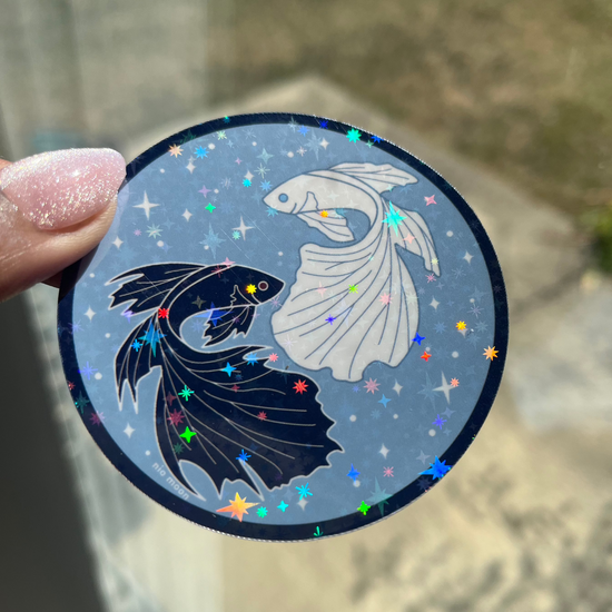 a close up photo of the black outlined sticker of gleaming holographic stickers of black and white betta fish