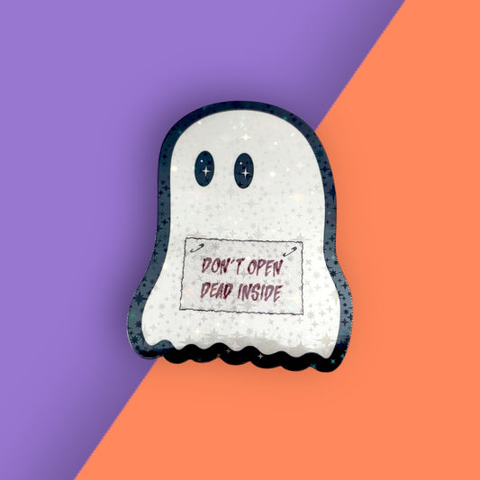 holographic vinyl sticker of a ghost holding a sign that says, "don't open, dead inside" on a purple and orange background